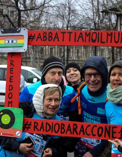 Le famiglie dei beneficiari fanno una foto con una cornice creata dal laboratorio di Radio (Baraccone13) alla mezza maratona di Torino